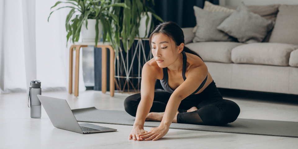 Woman stretching in yoga mat at home