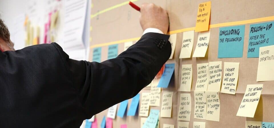Man sticking and writing postits